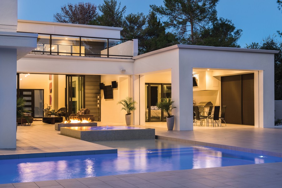  The outside of a modern home featuring Lutron lights.