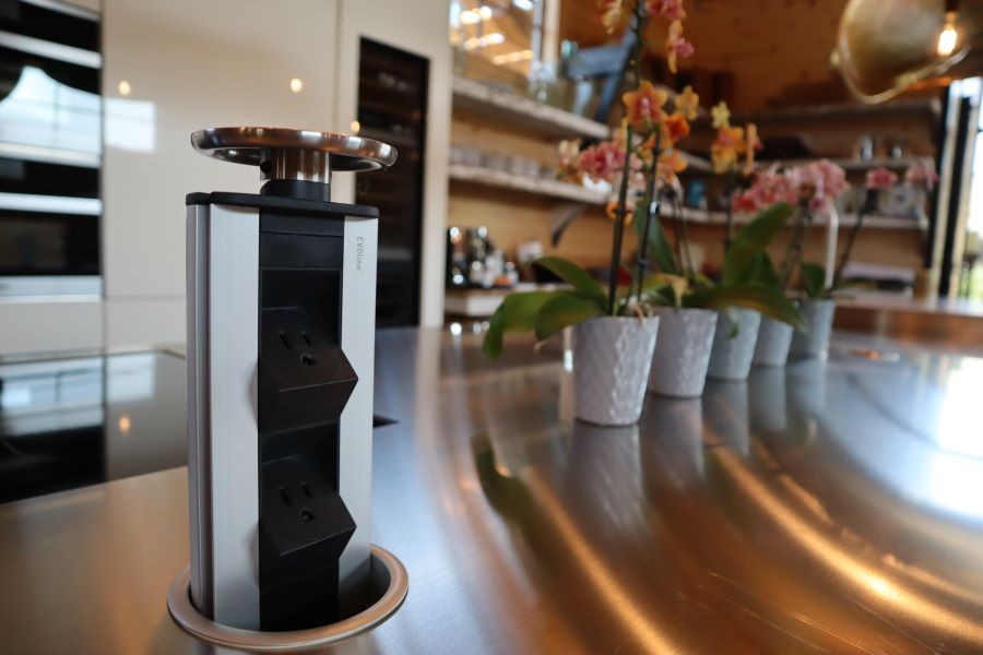 A kitchen with a power strip that pulls up from a countertop, hiding when not in use. 