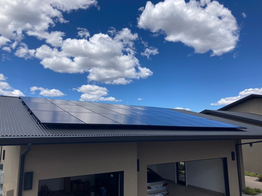 A view of solar panels on the metal roof of a large home. 