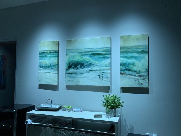 A wide-angle view of a contemporary room designed for home entertainment, featuring integrated theater equipment, modern seating, and ambient lighting arranged in a polished layout.