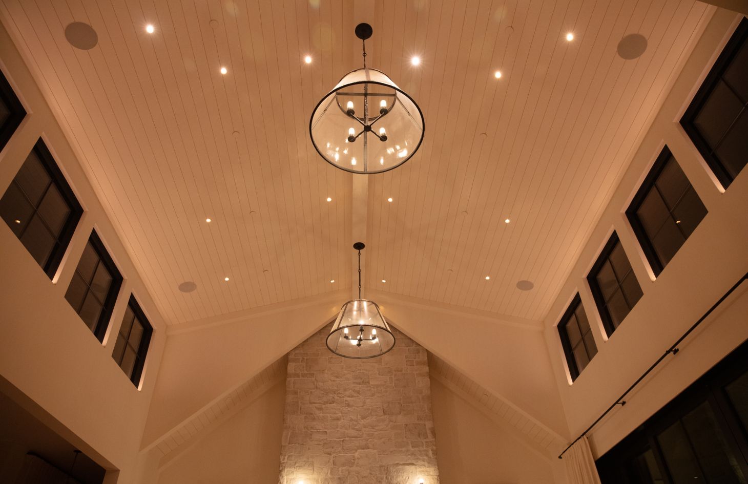 A bright, modern kitchen with glossy cabinetry, a spacious central island with bar seating, and large windows that offer abundant natural light.