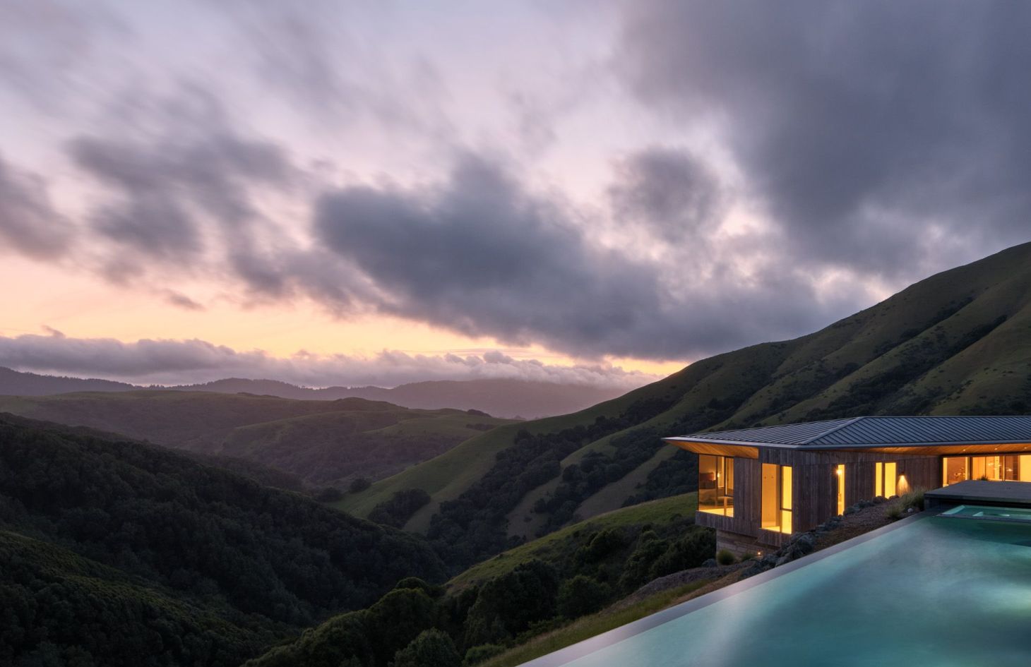 The estate’s pool and wood-clad wing at dusk above the Marin County hills.
