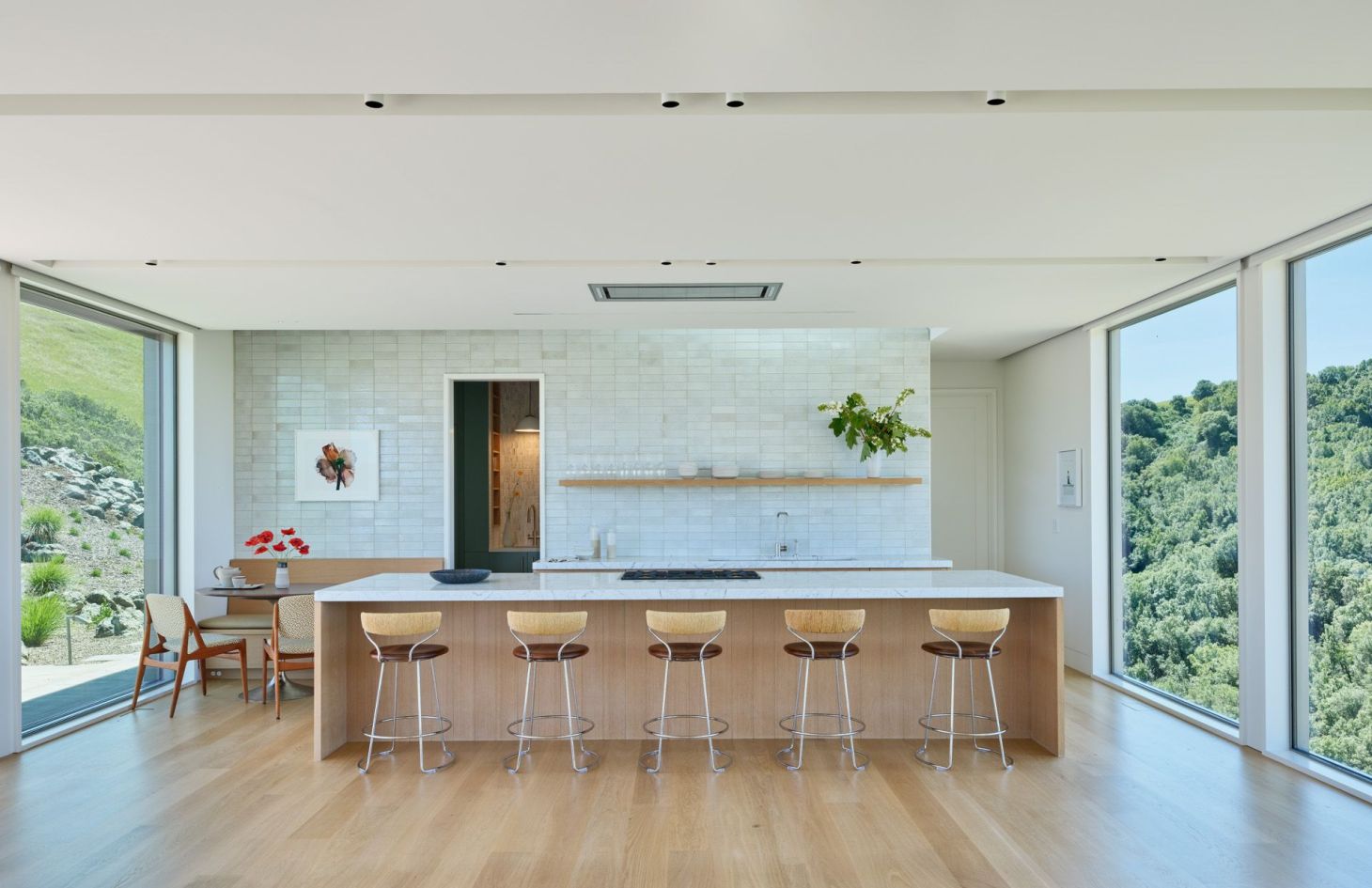Kitchen with a long island and hillside views, with every appliance powered by the estate’s off-grid solar and battery system.