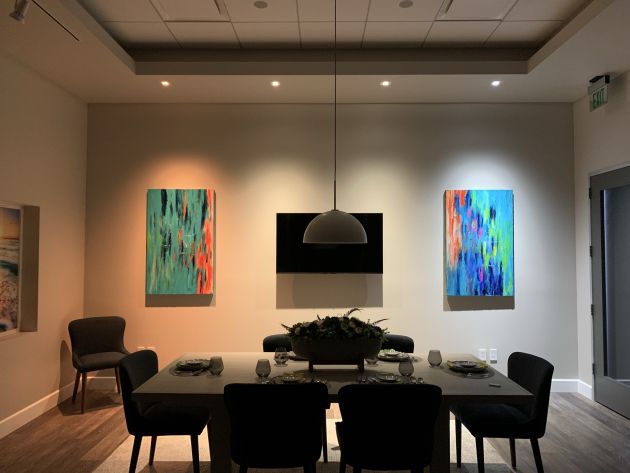 A detailed photograph of a stylish living space with minimalist decor, including a wall-mounted television, modern seating, and subtle accent lighting that creates an inviting atmosphere.