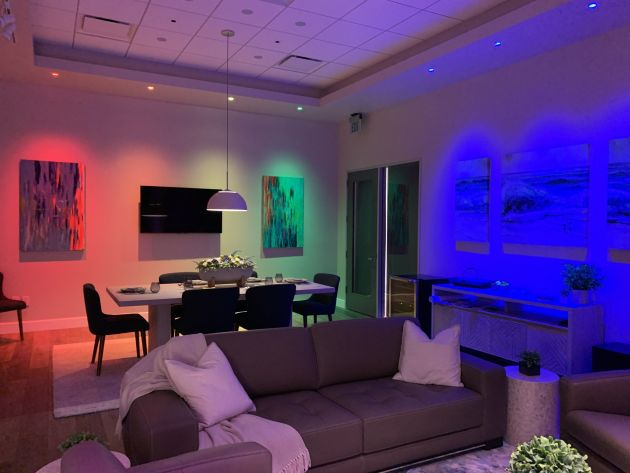 An inviting interior shot of a modern living area with comfortable seating, a flat-screen TV, and artistic decor elements that contribute to a warm, sophisticated environment.