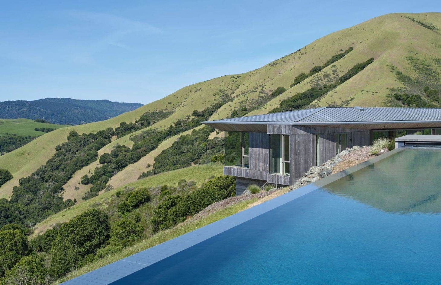 Infinity-edge pool at the off-grid estate overlooking the Marin County hills; pool equipment runs on an intelligent load-management schedule.