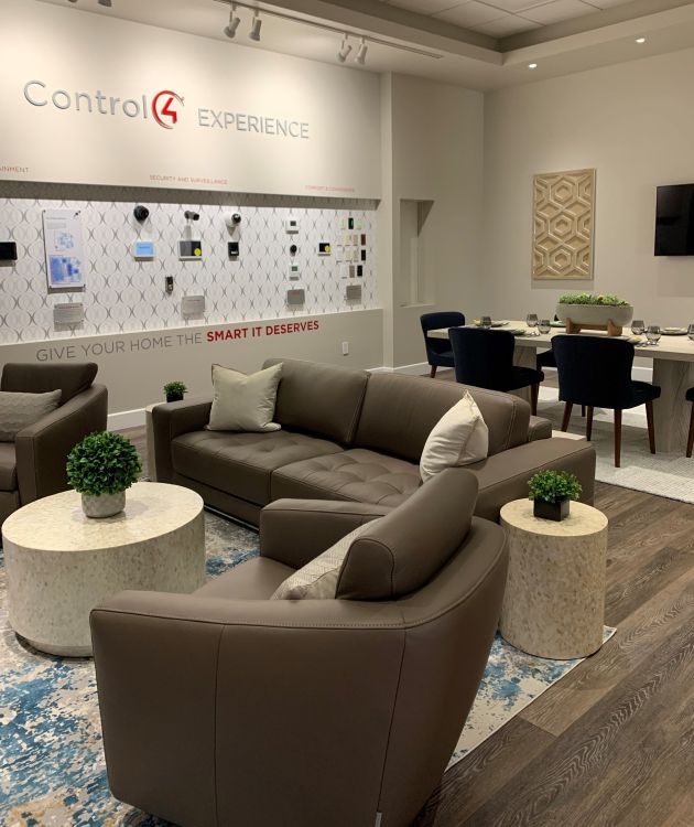 A wide-angle view of a high-end showroom displaying luxury home automation and audio-visual products, with polished surfaces, modern lighting, and stylish furnishings.